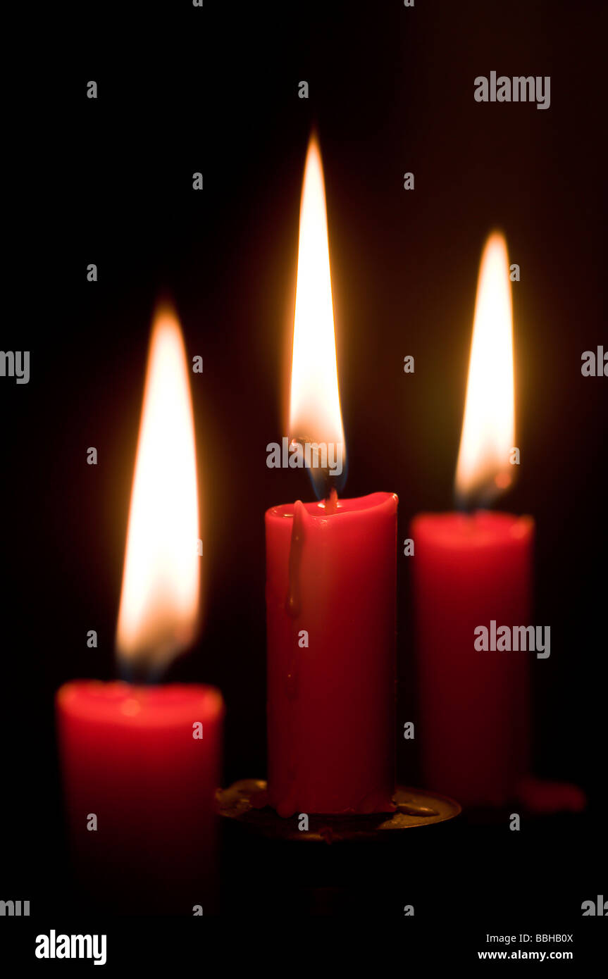 Three candles flaming in the dark Stock Photo Alamy
