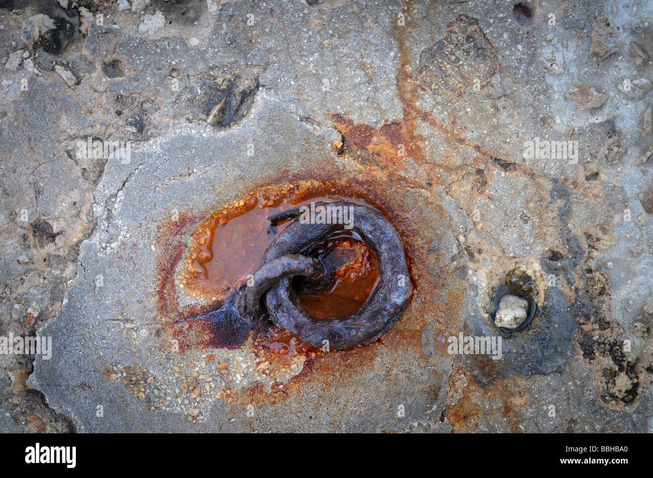 Rusted chain link in a rock Stock Photo