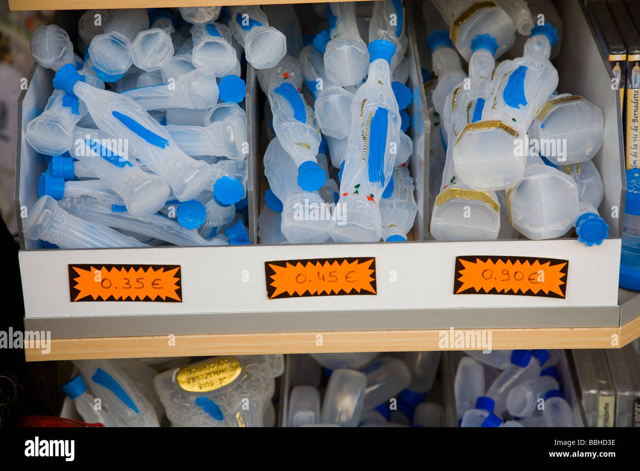 Souviner water bottles in the shape of the Virgin on display in Lourdes France Stock Photo