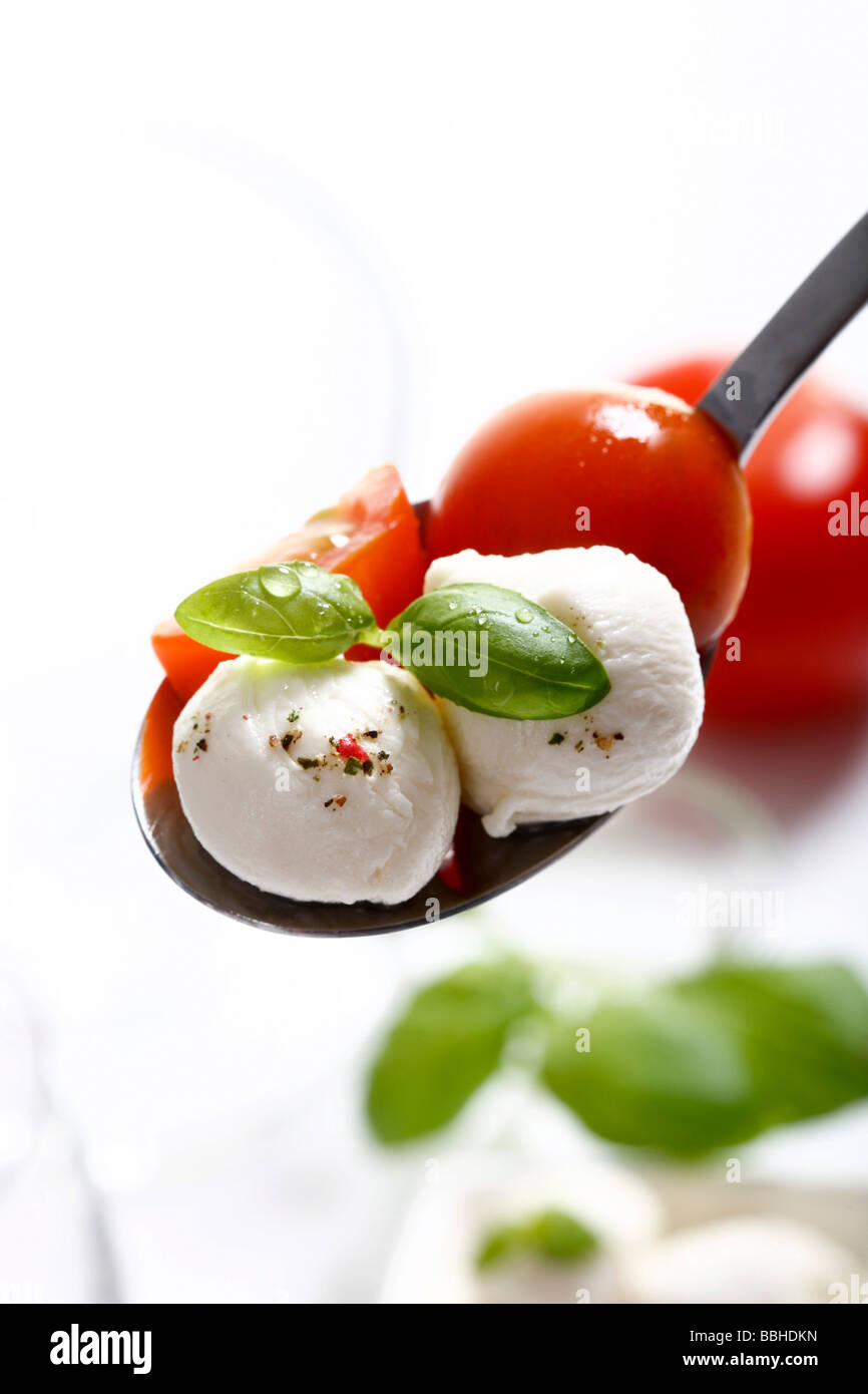 Tomatoes, mozzarella and basil on a spoon Stock Photo
