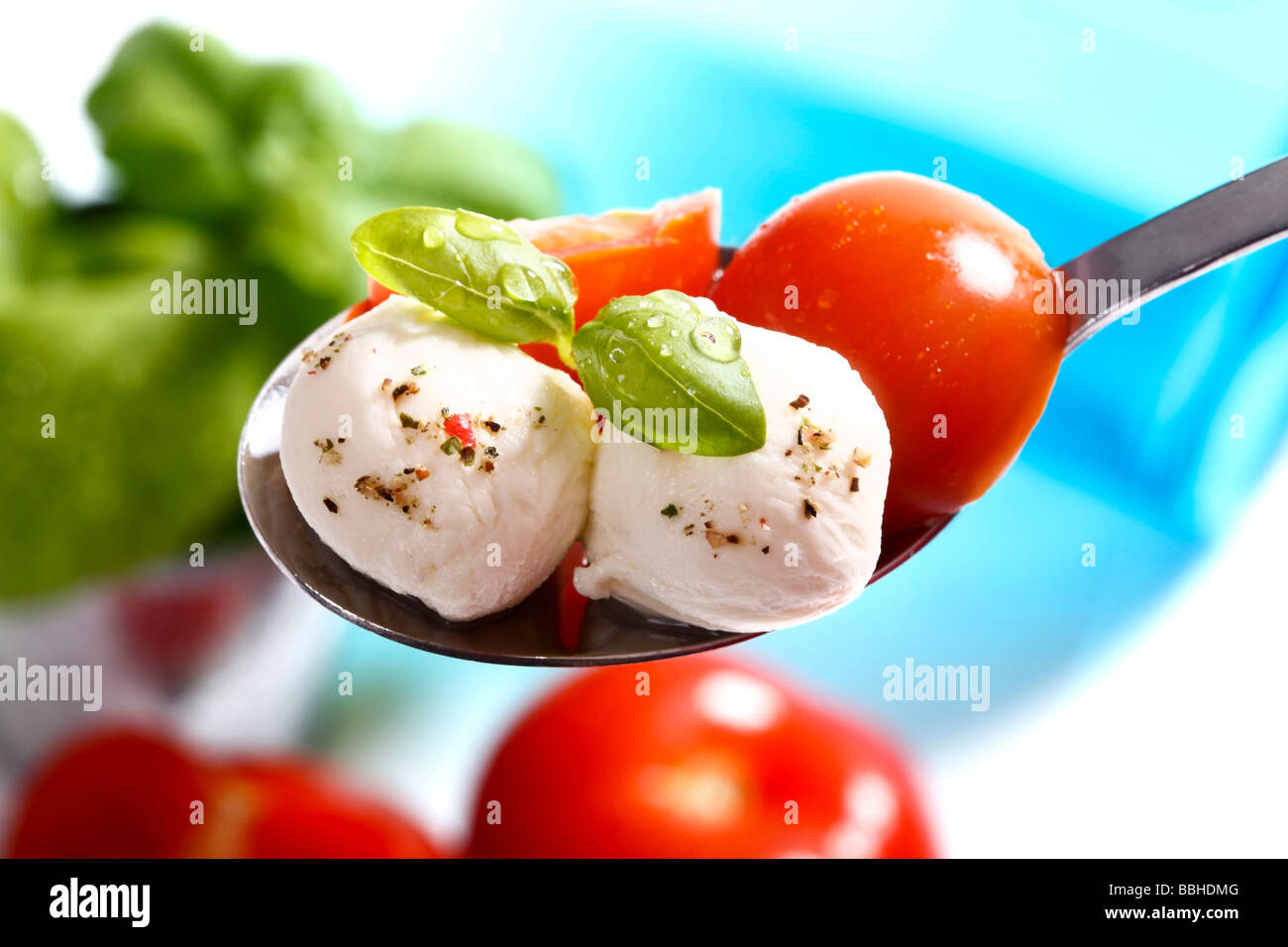 Tomatoes, mozzarella and basil on a spoon Stock Photo