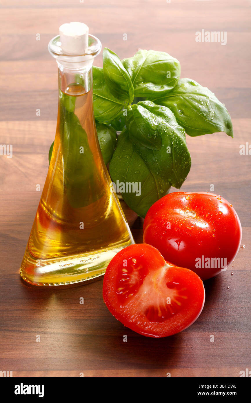 Tomatoes, olive oil and fresh basil on a wooden table Stock Photo
