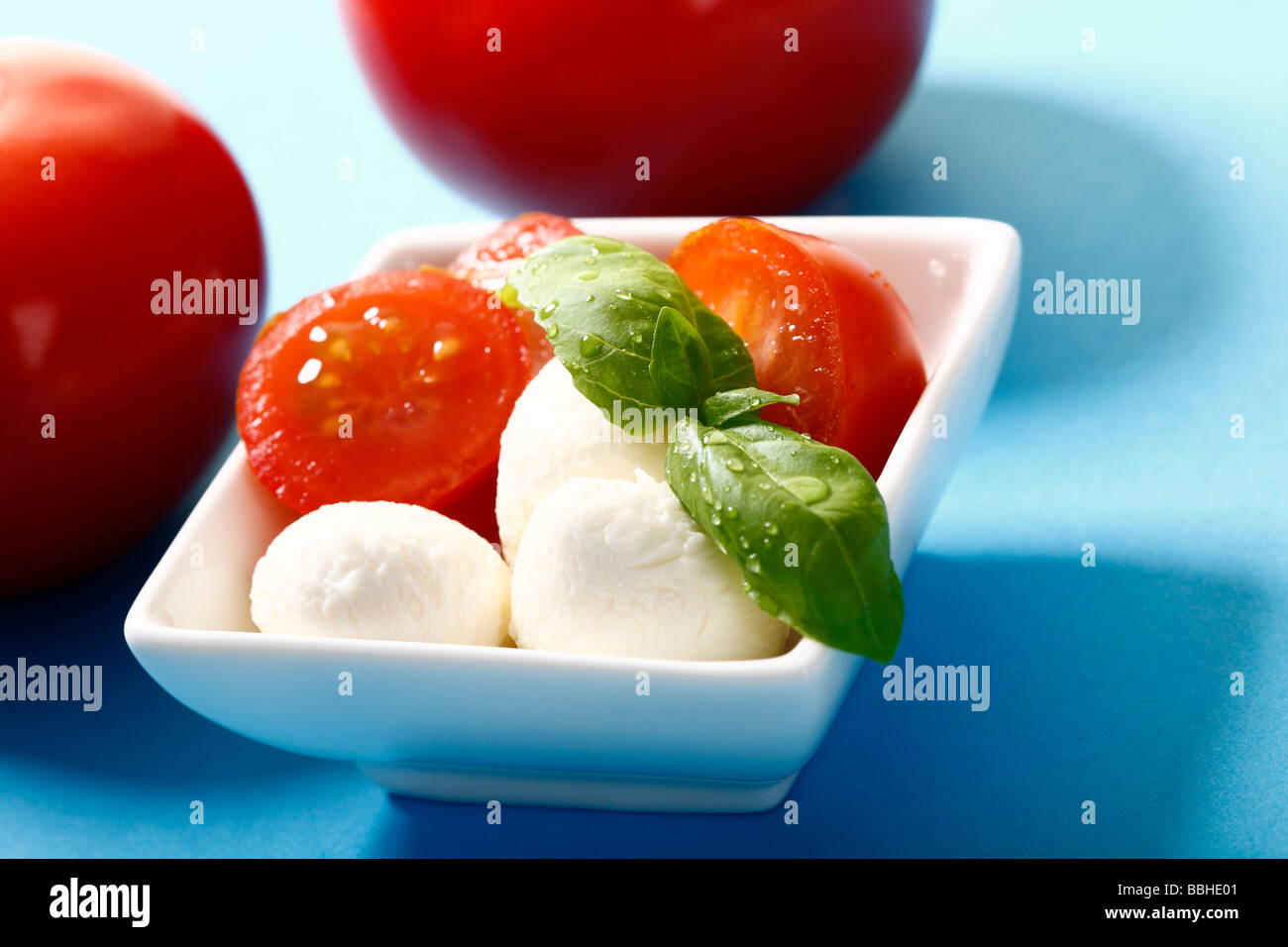 Tomatoes and mozzarella with basil on a dish Stock Photo