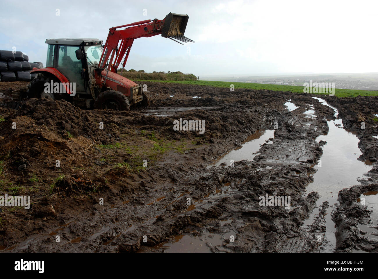 Tractor in a muddy field, UK Stock Photo Alamy