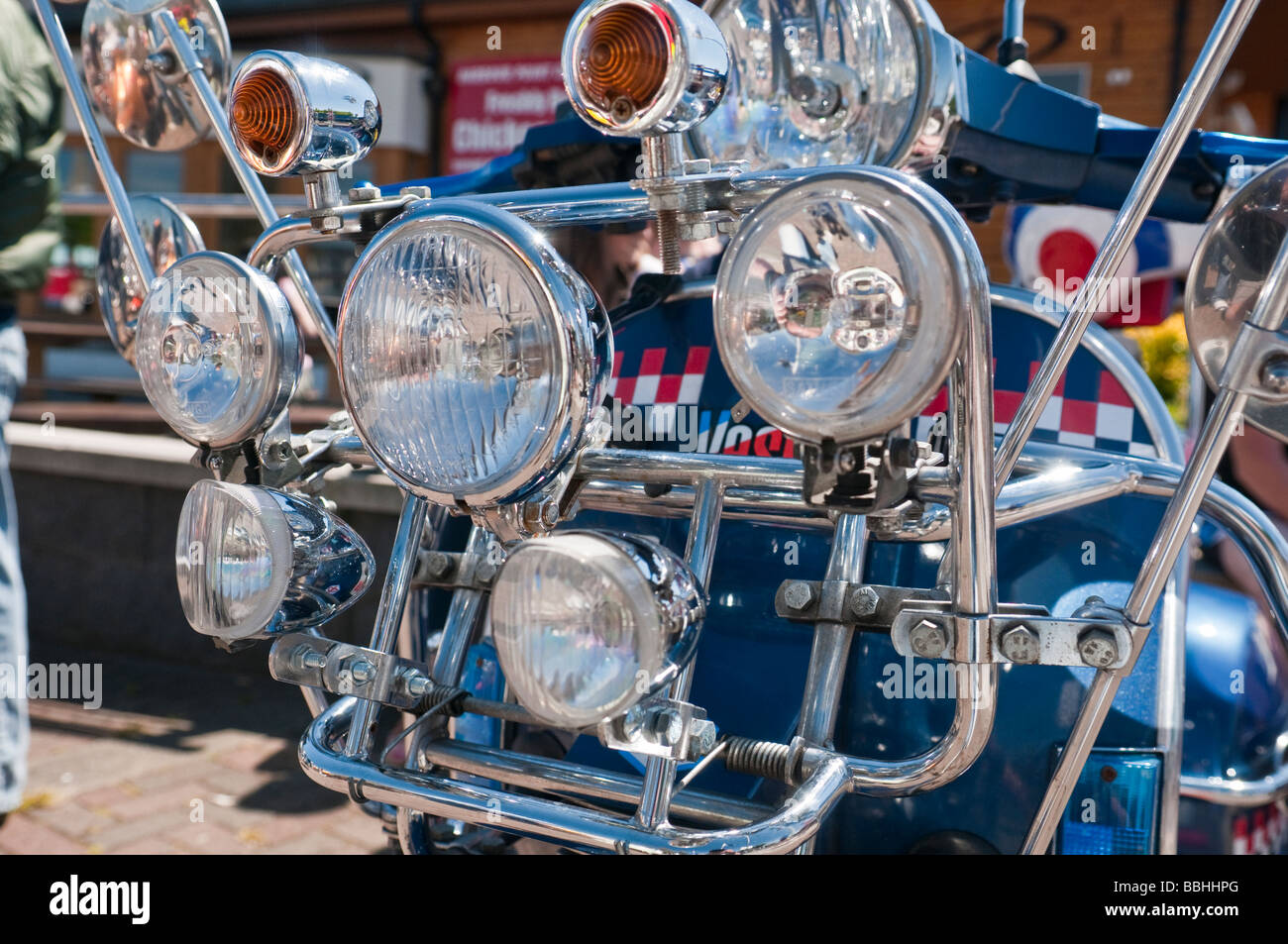 Blue Vespa scooter with lots of chrome and headlights lights. Stock Photo