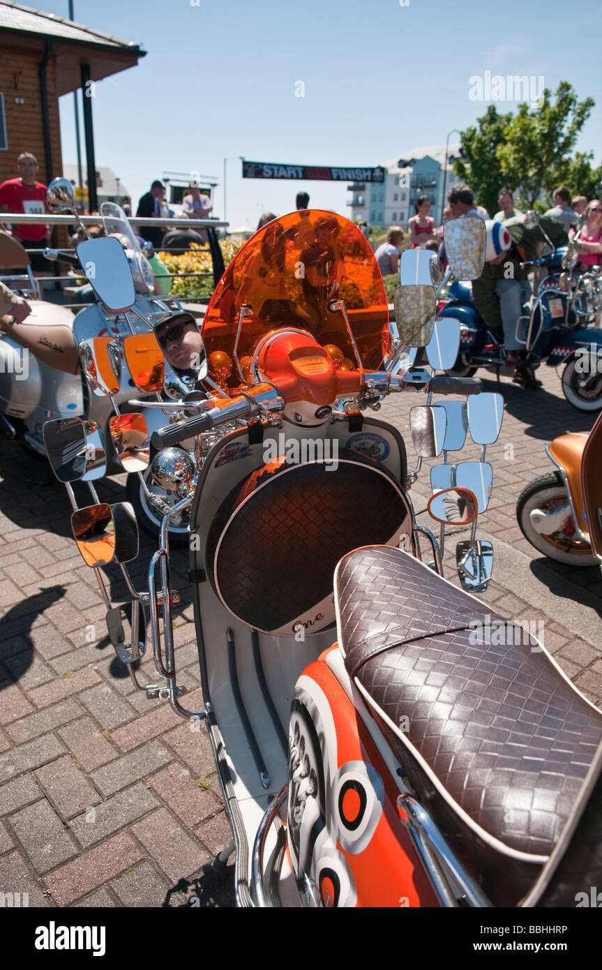 Orange Vespa scooter with lots of mirrors and lights Stock Photo