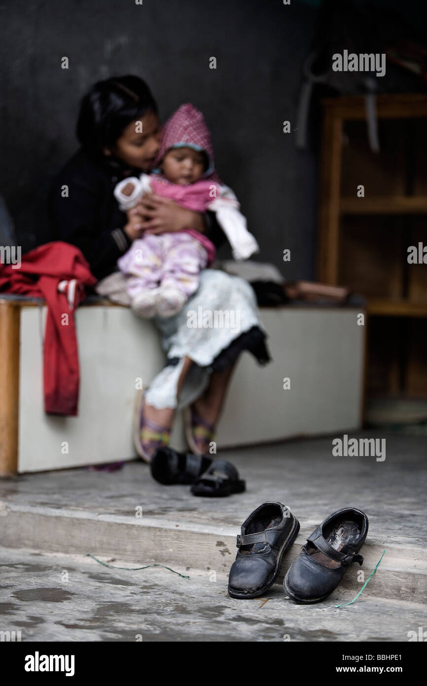 Pokhara, Nepal; Orphaned girl holding baby at orphanage Stock Photo