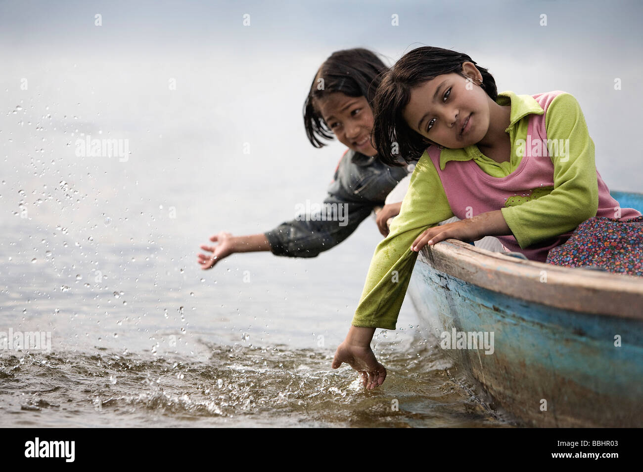 Pokhara, Nepal; Orphaned girl sitting in boat Stock Photo
