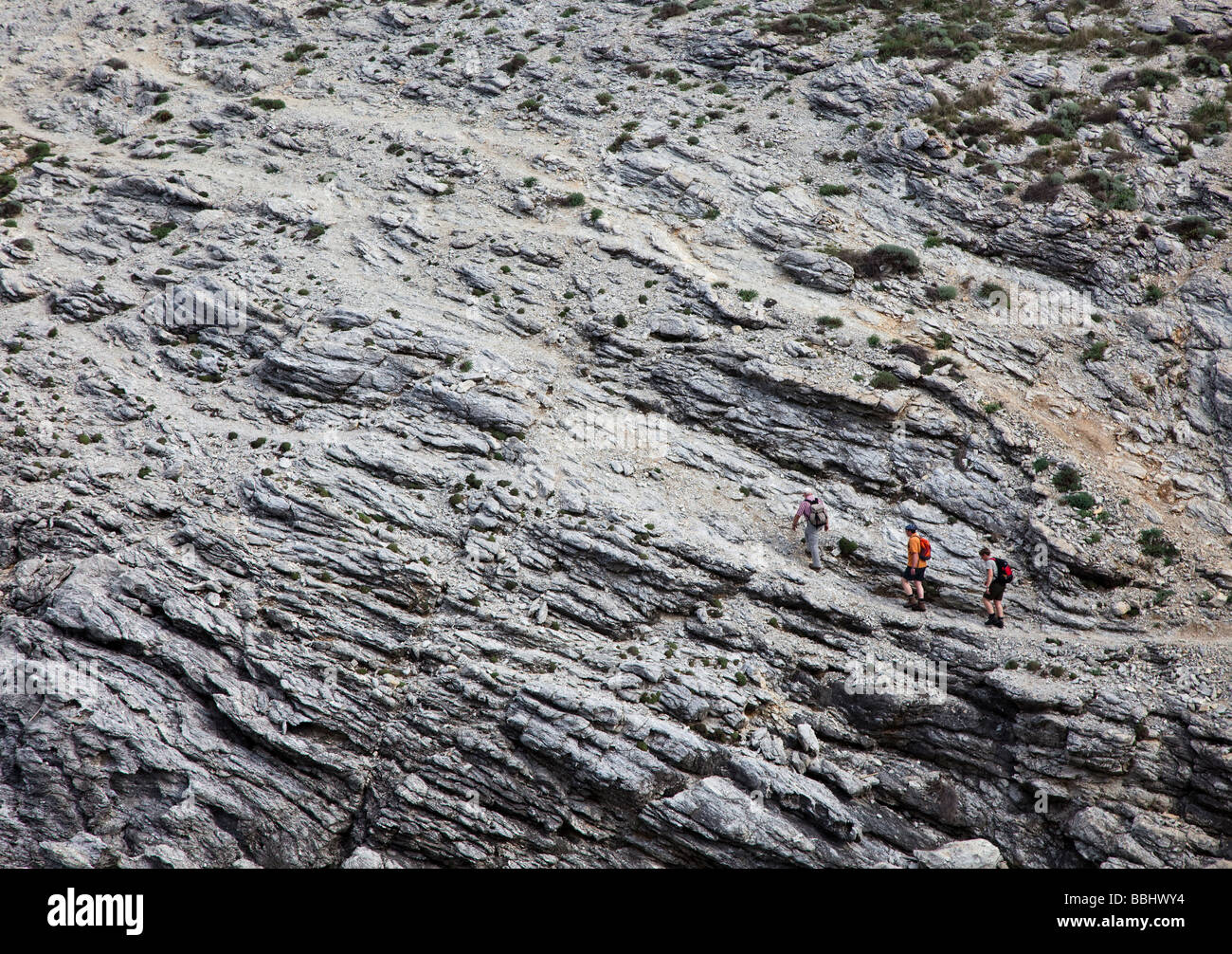 Three hikers on cliff path eastern Mallorca Spain Stock Photo