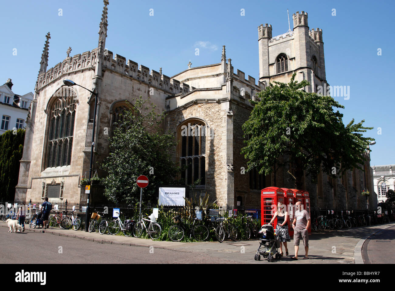 a couple strolling with a pram outside great st marys church market square cambridge uk Stock Photo