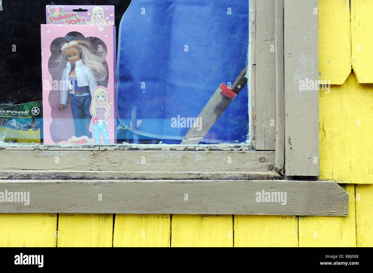 Doll and knife in a window Stock Photo Alamy