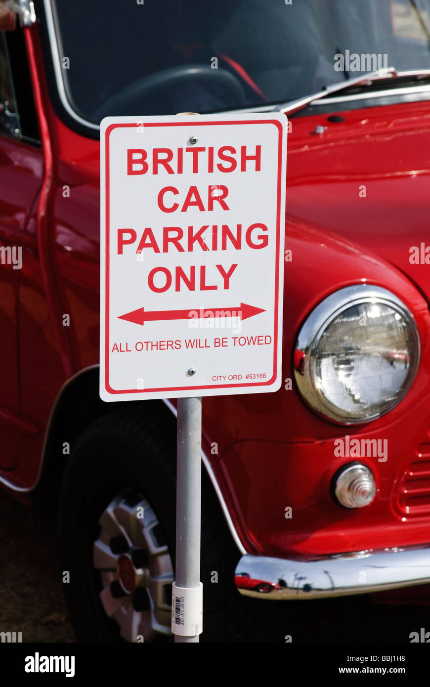 British Car Parking Only sign in front of a red Mini Cooper car Stock Photo