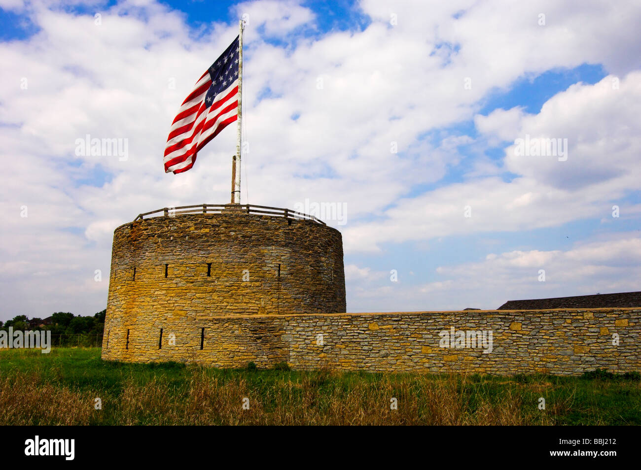 Stone wall of fort with gun tower and United States flag at historic