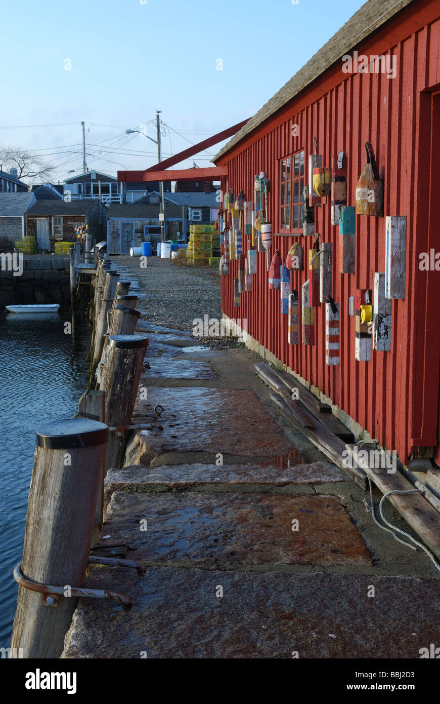 Lobster trap floats on side of fishing shack and dock Rockport harbor