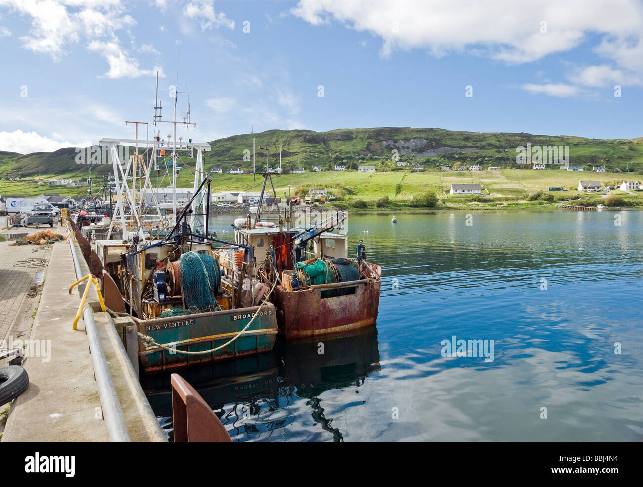 The small fishing harbour and ferry terminal of Uig in Skye Scotland with boats moored at the pier Stock Photo