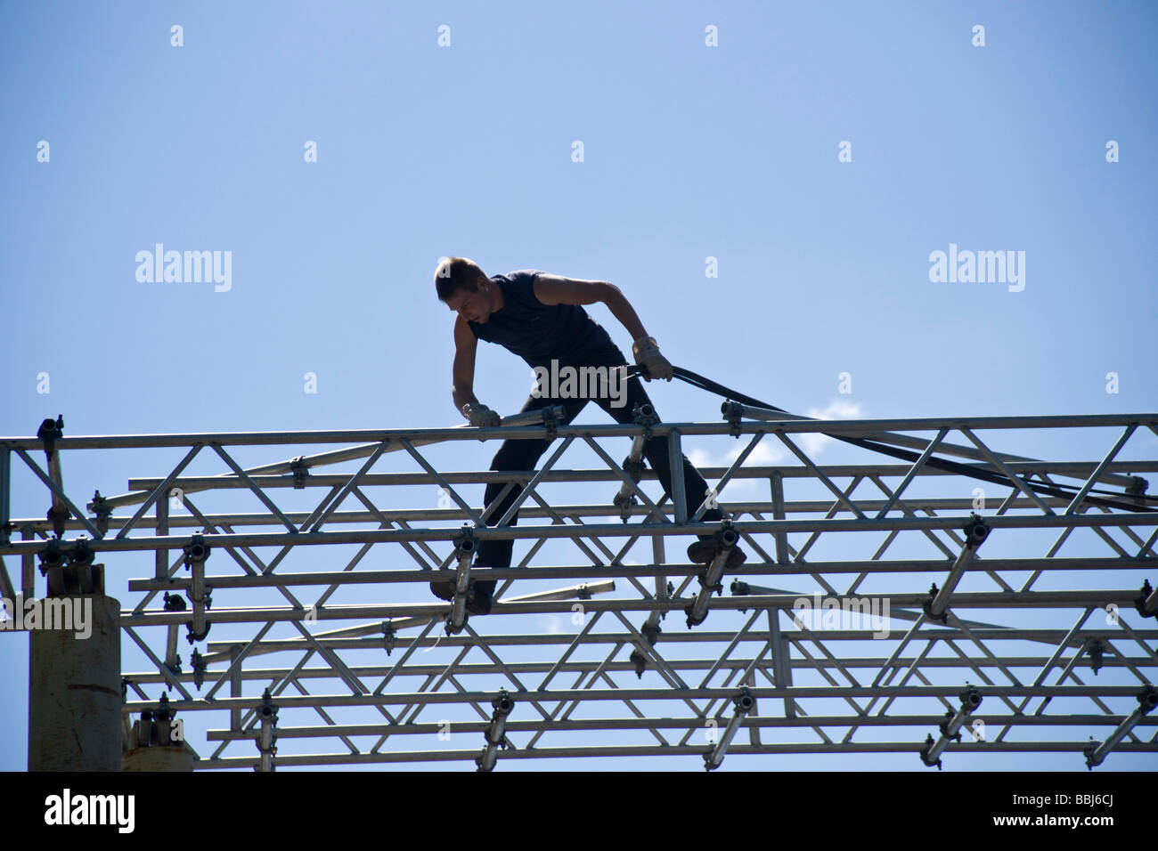 Construction worker laying electrical cable on a scaffold, Berlin, Germany, Europe Stock Photo