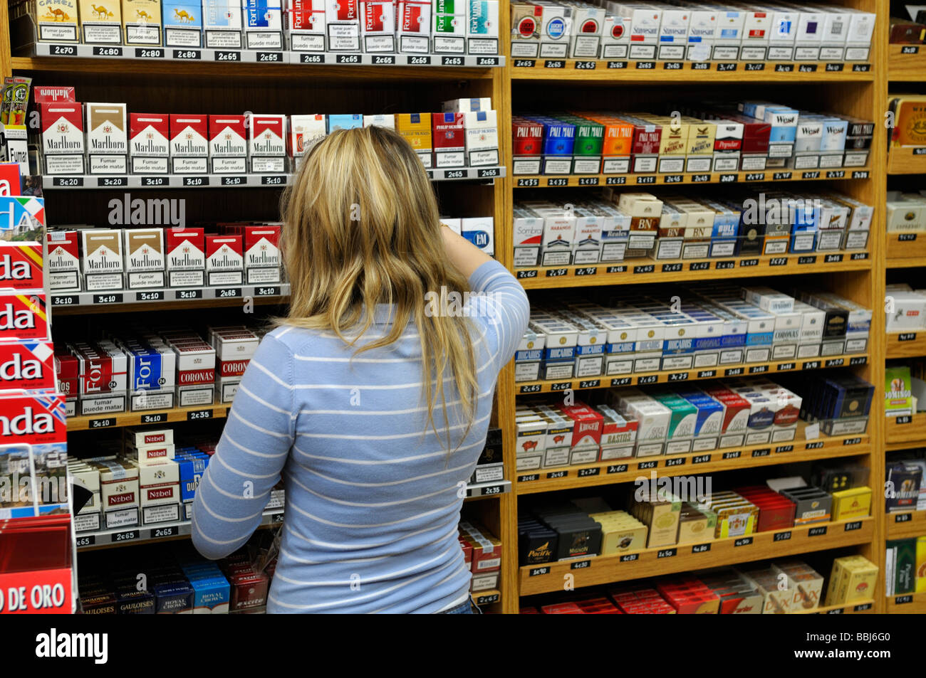 Woman behind counter in tobacconists shop Spain Stock Photo
