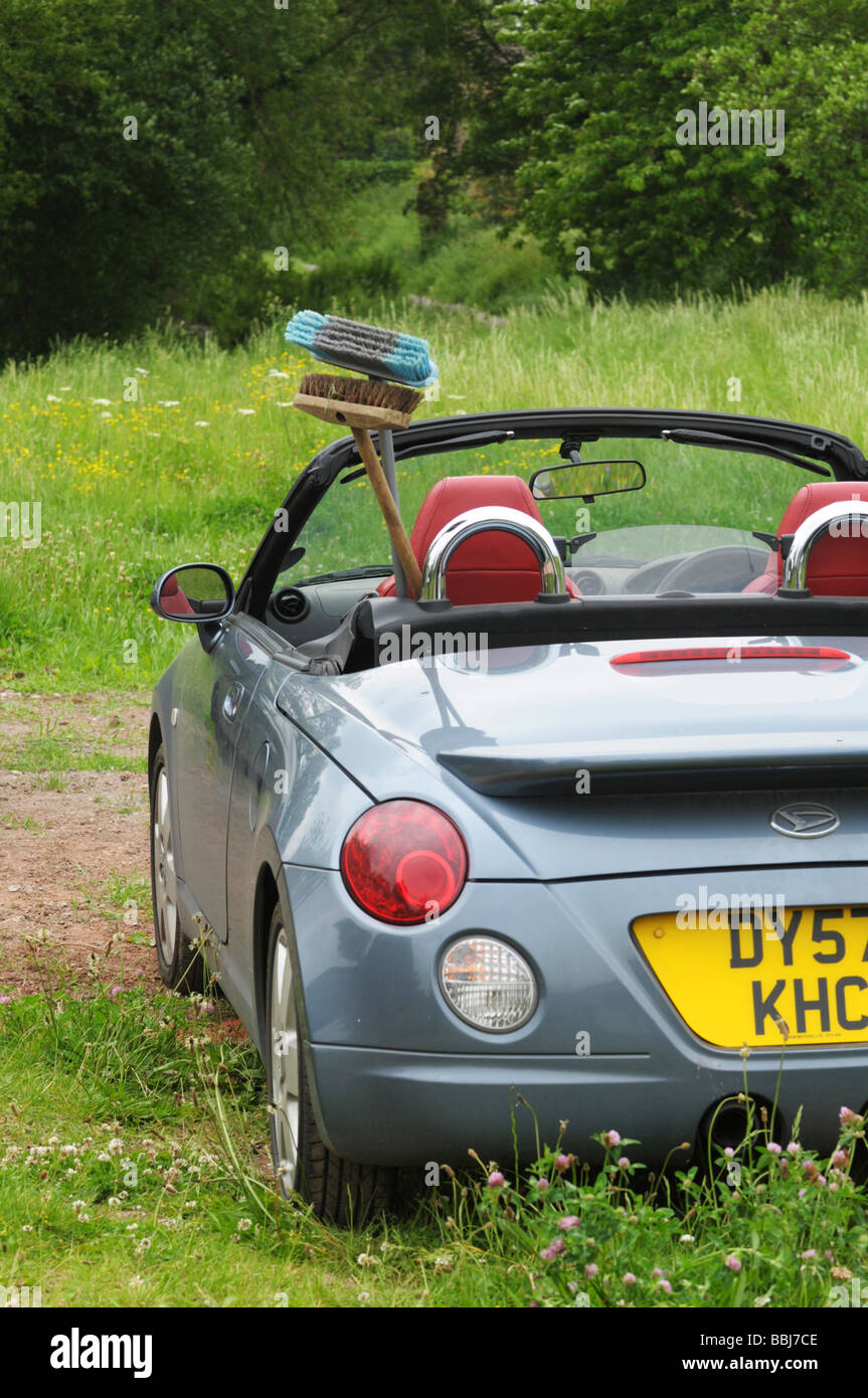 Daihatsu Copen sports car with brooms sticking out Stock Photo