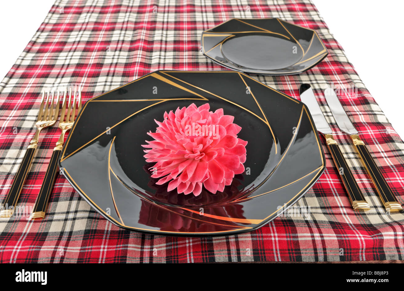 Table setting with black plates and gold cutlery Stock Photo