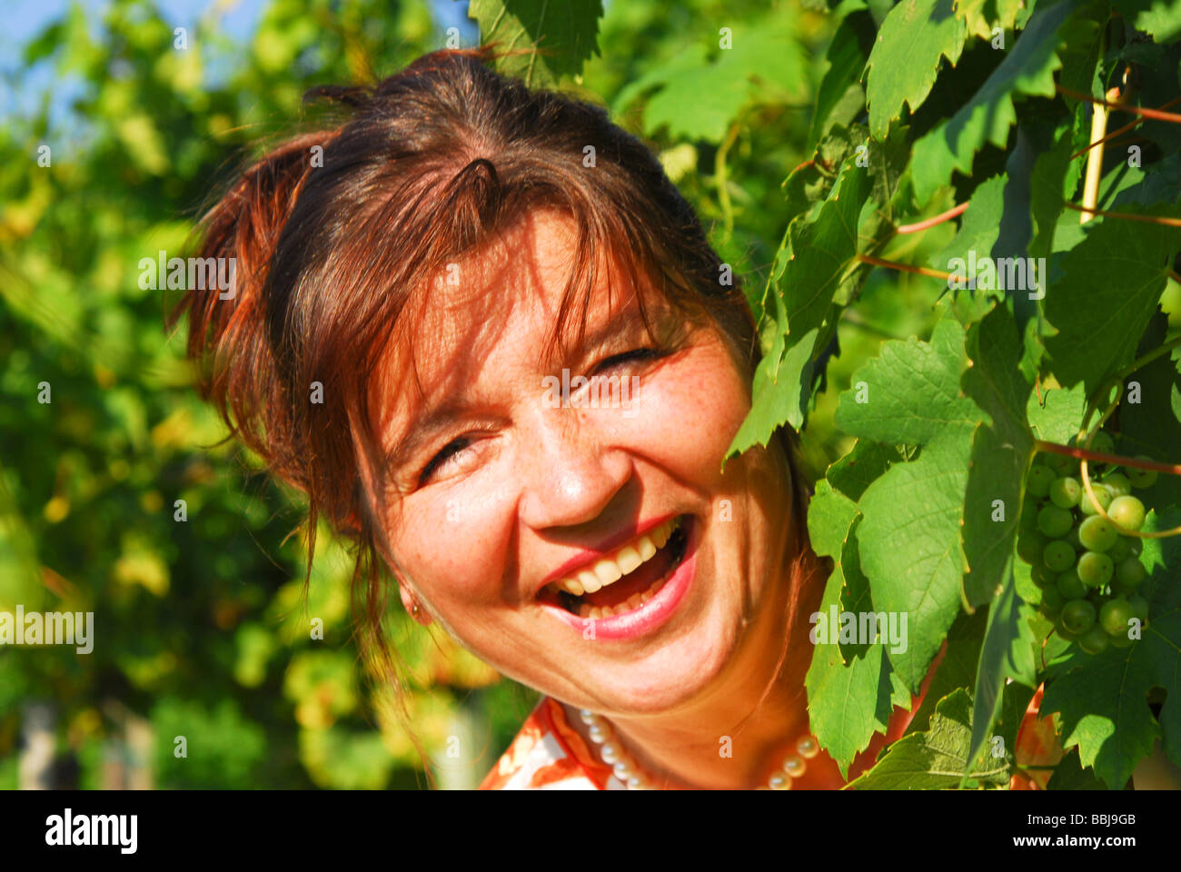 Woman smiling in a wineyard Stock Photo