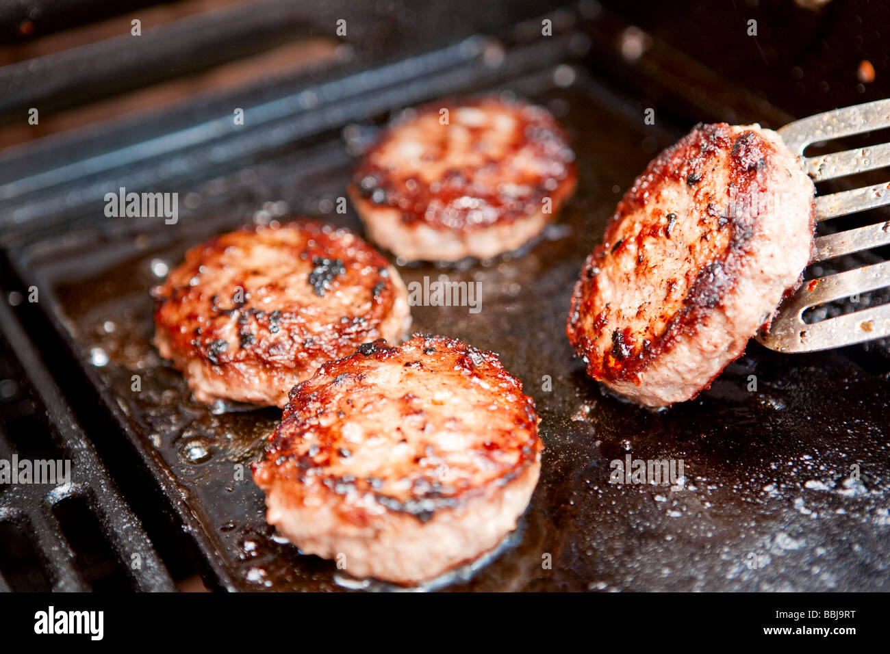 Burgers cooking on a barbecue selective focus Stock Photo