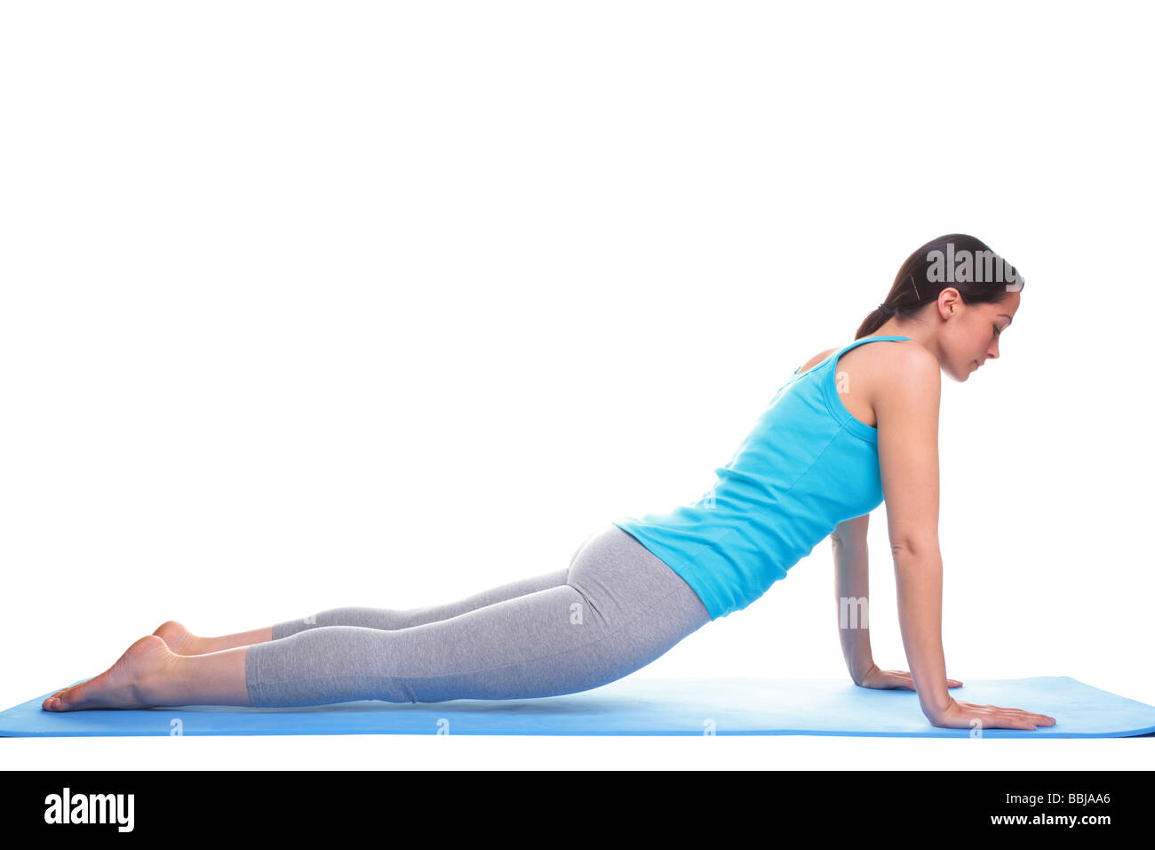 A brunette woman doing stretching exercises on a yoga mat isolated on a ...