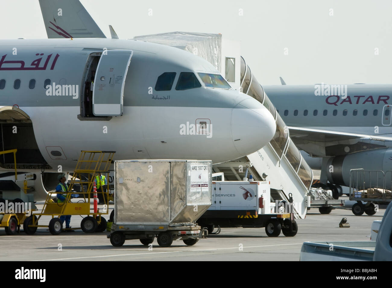 Qatar Airways aircraft being loaded with containers at Doha Airport in Qatar Stock Photo