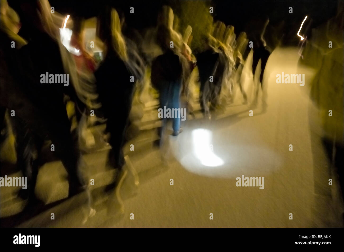 group of people move down a street at night Stock Photo Alamy