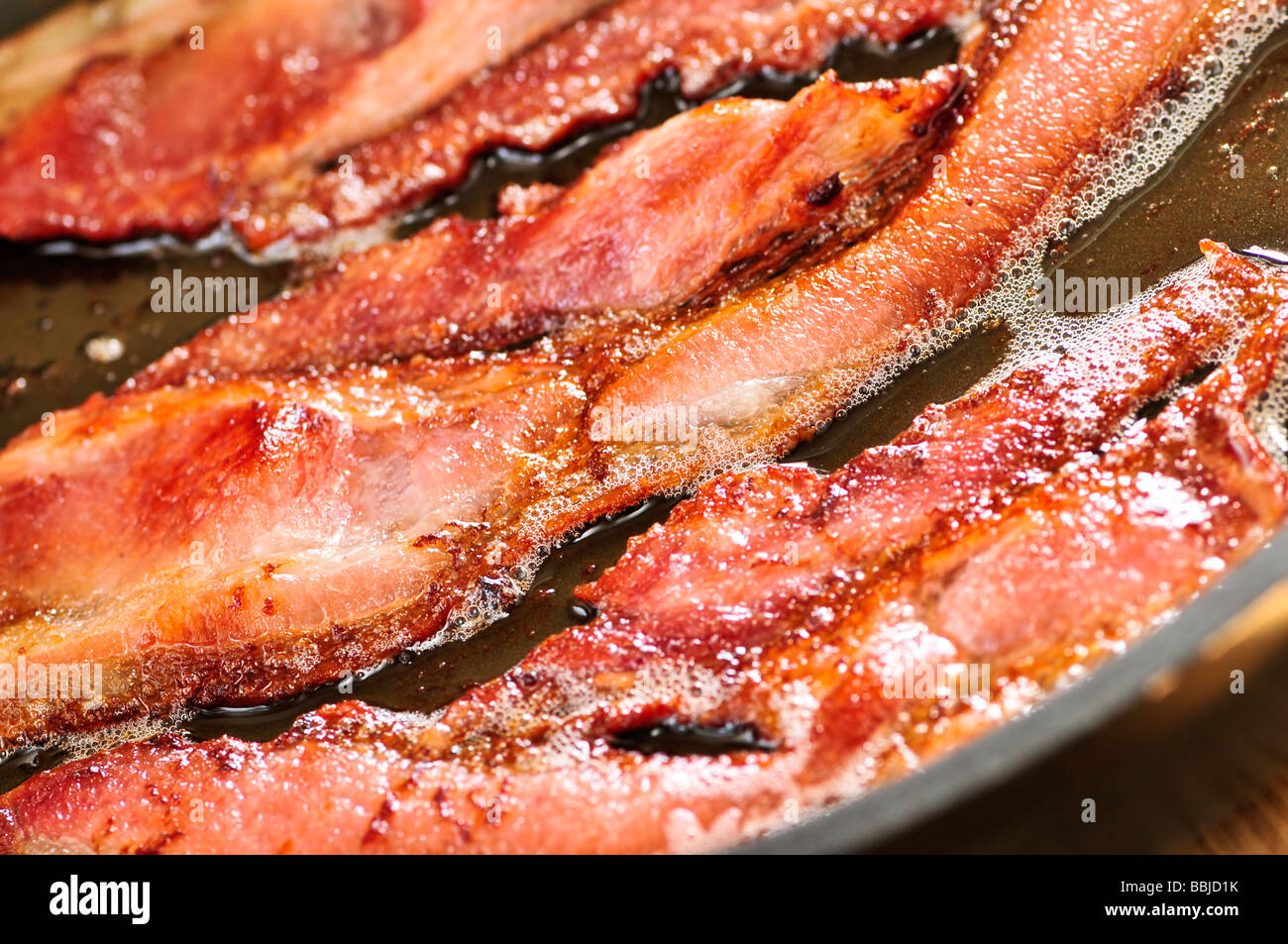 Bacon cooking in a frying pan Stock Photo - Alamy