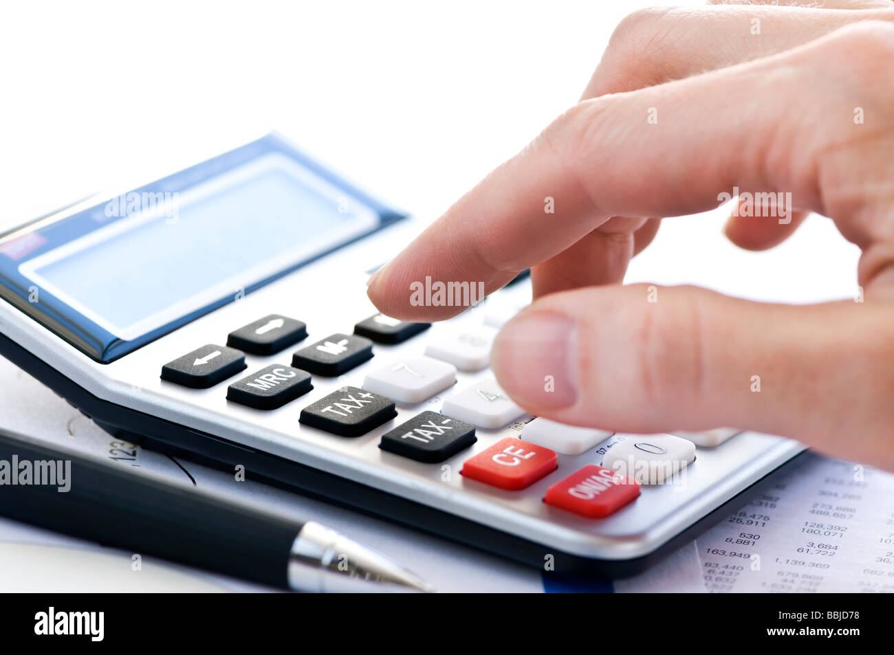 Typing numbers for income tax return with pen and calculator Stock Photo