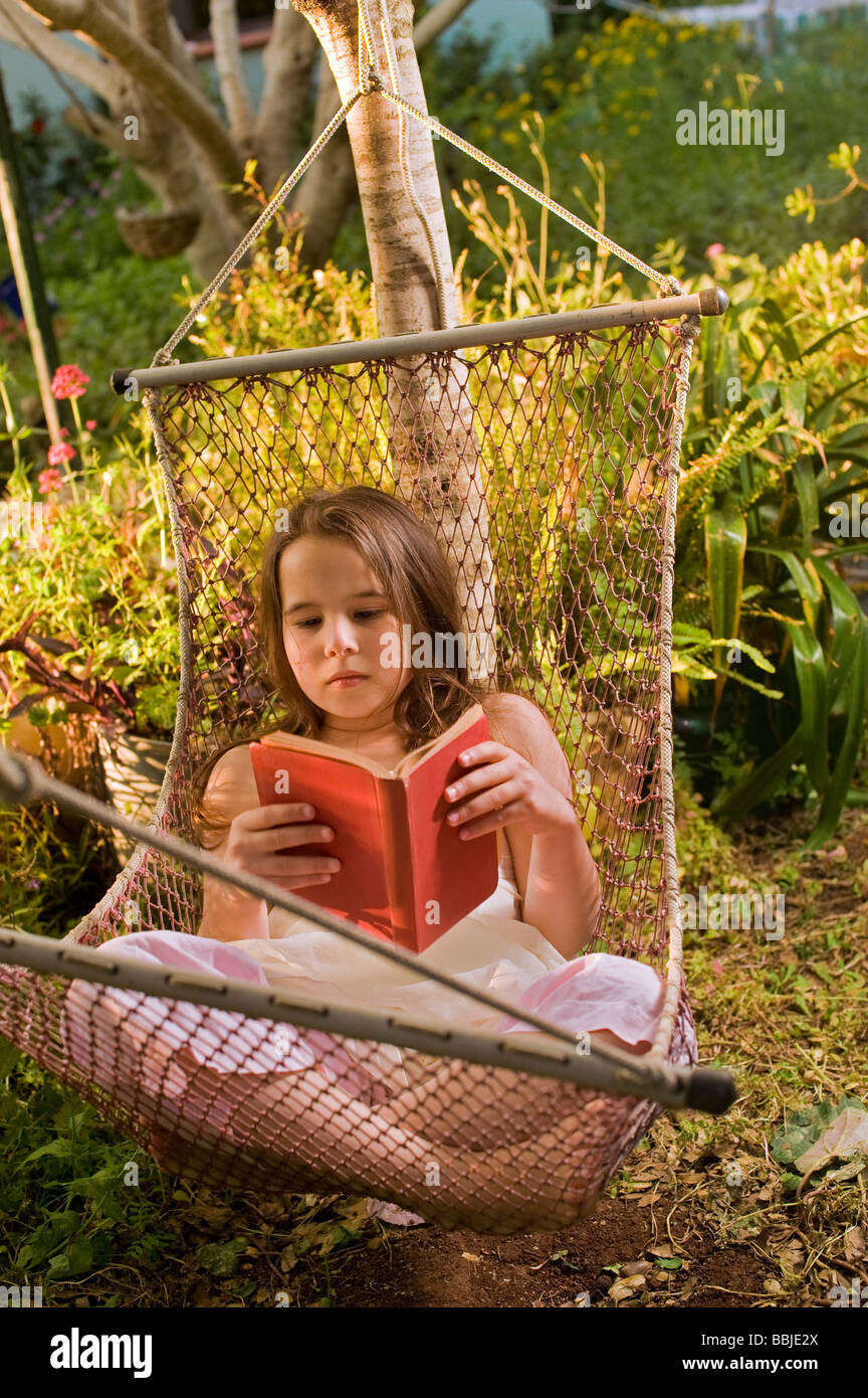 young girl reading a book on a hammock Stock Photo - Alamy