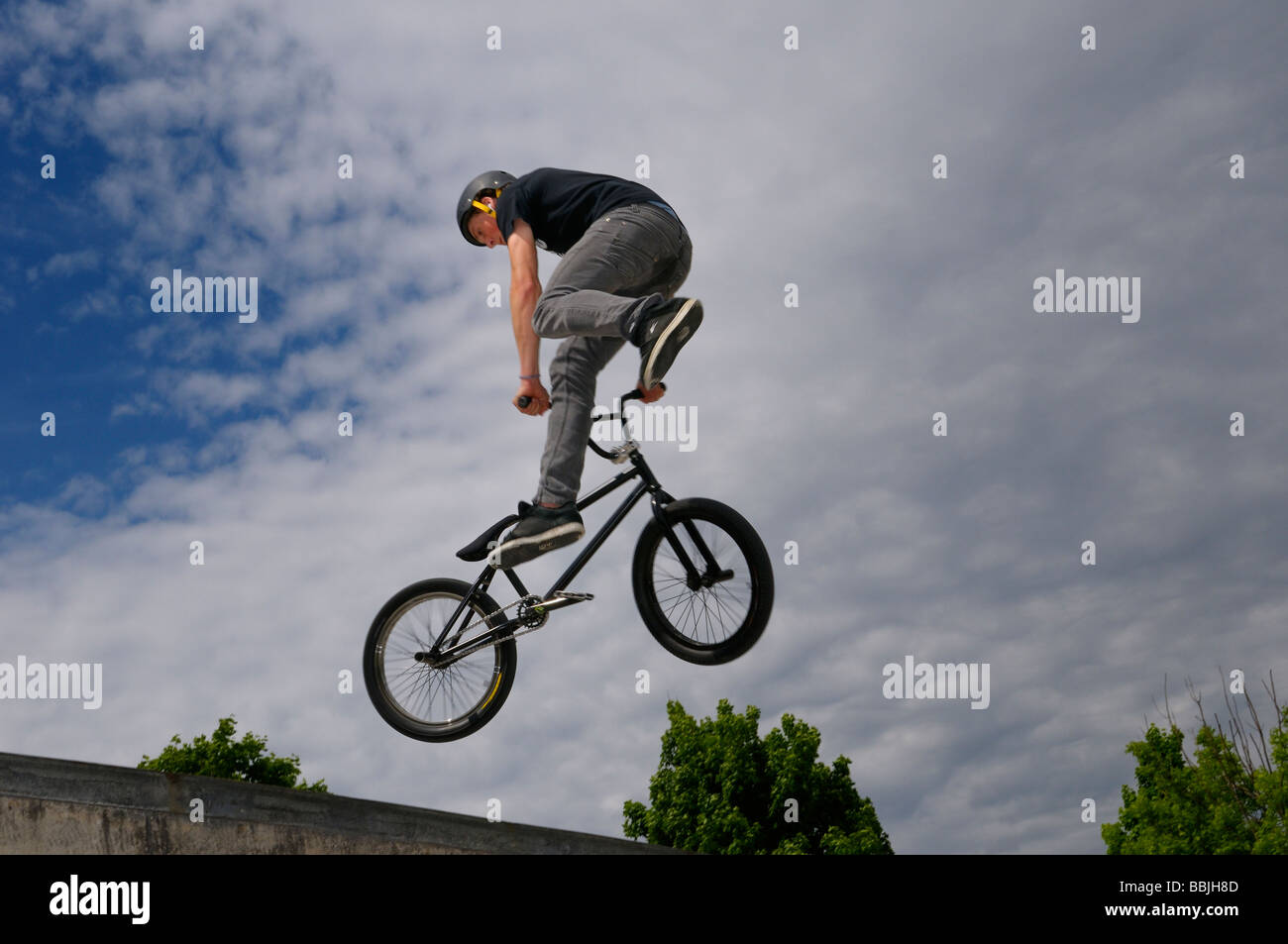 BMX bike rider exiting a bowl air out with a Tail Whip 360 spin Toronto skatepark Stock Photo