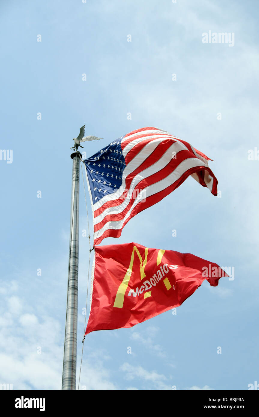 Flagpole with the Stars Stripes flag above the McDonalds company flag flying Stock Photo
