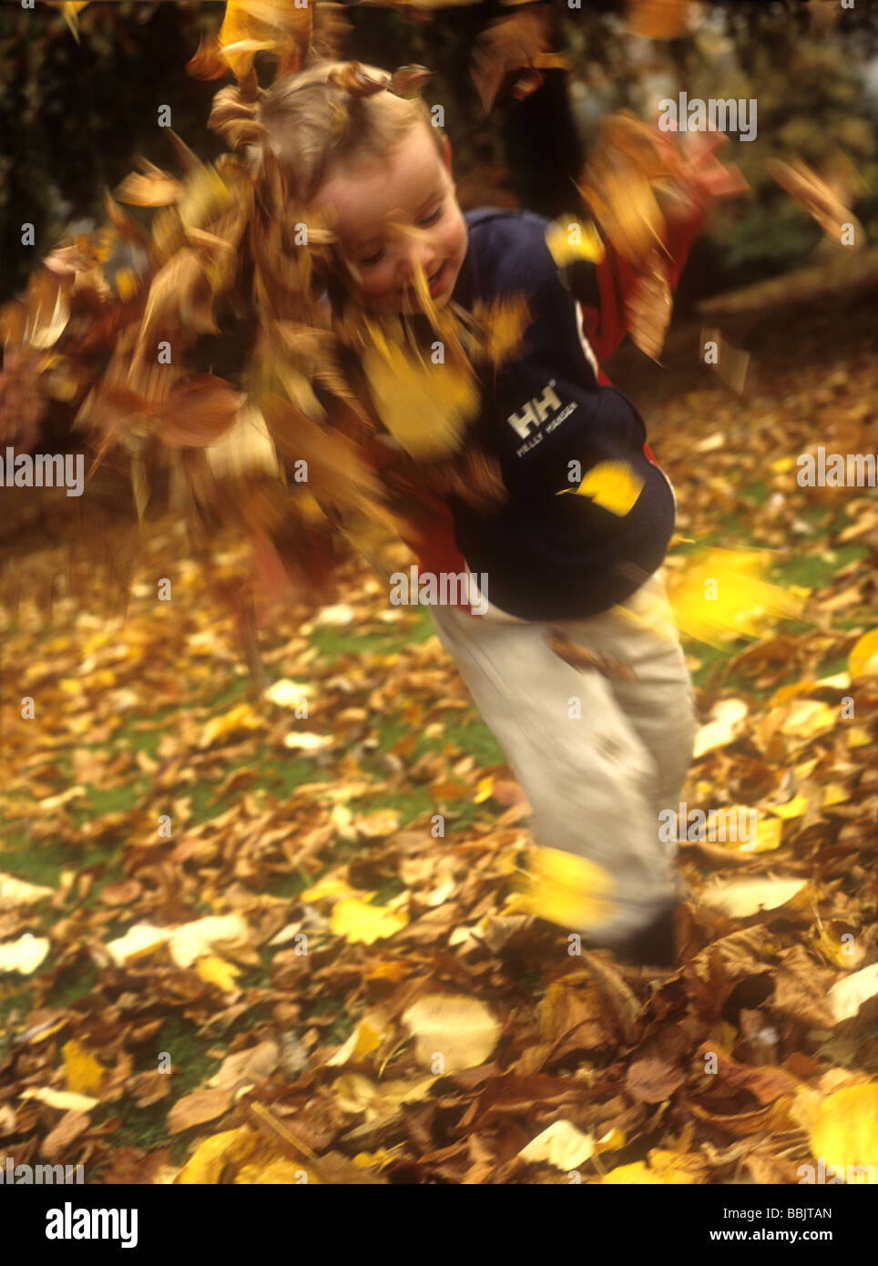 Young boy playing with autumn leaves Stock Photo - Alamy