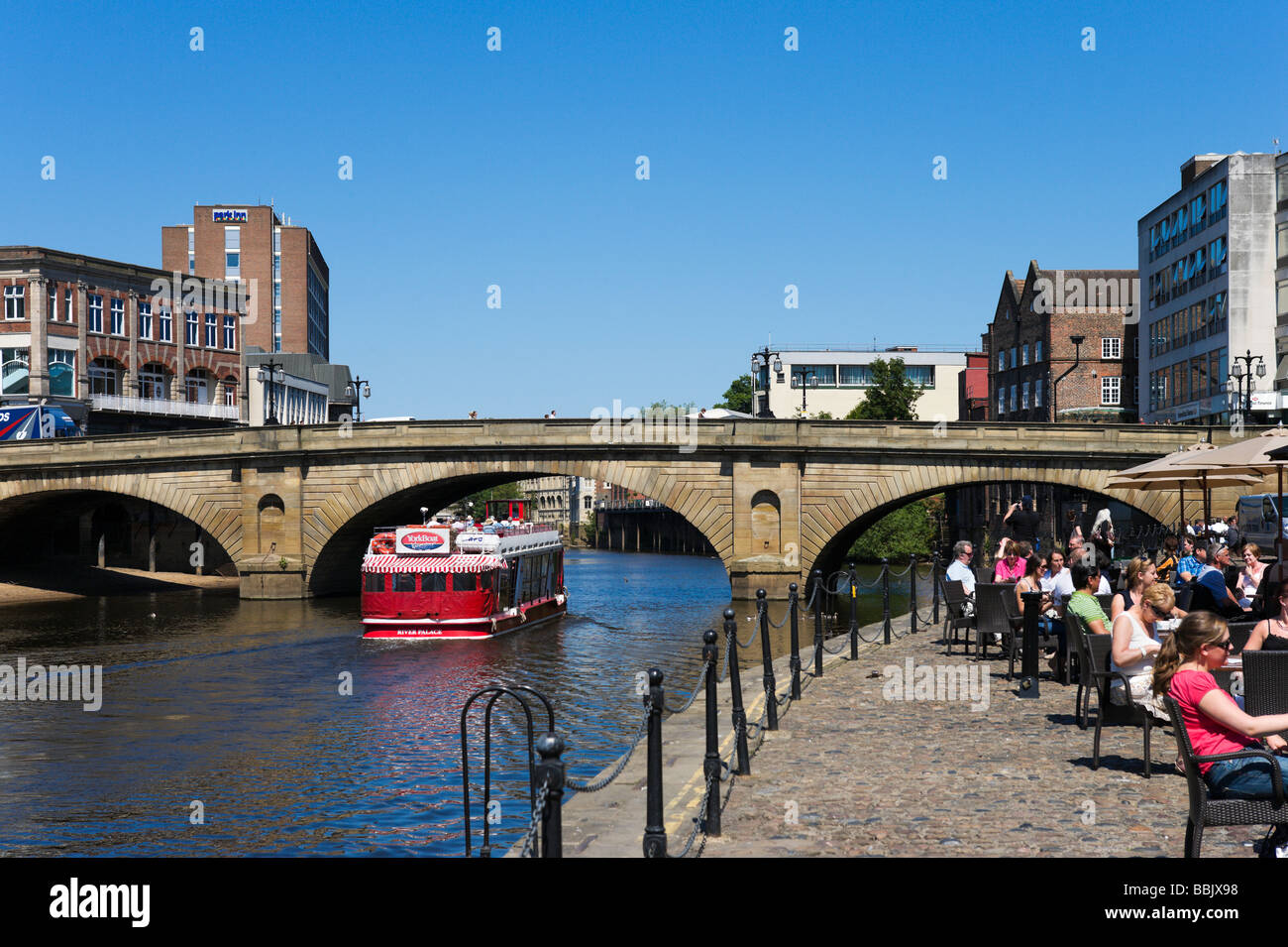 Tour boat going under Ouse Bridge near a pub on King's Staith, York, North Yorkshire, England Stock Photo