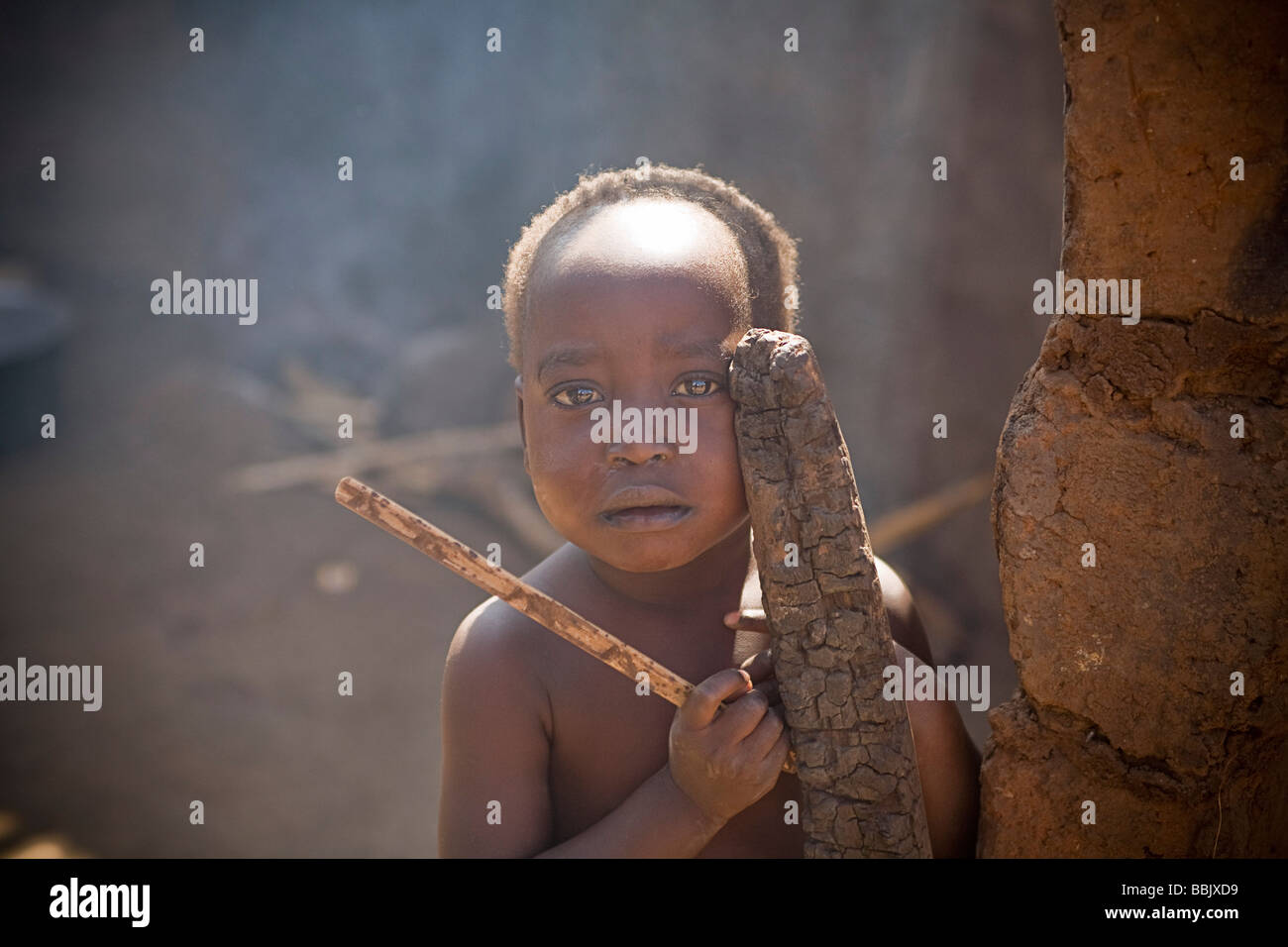 Koro-Abili IDP Camp, Gulu, Uganda; Portrait of young boy holding sticks Stock Photo