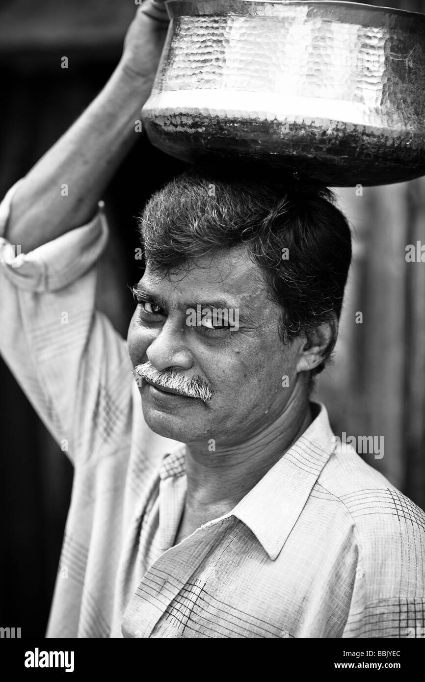 Portrait of man carrying a pot on his head hires stock photography and