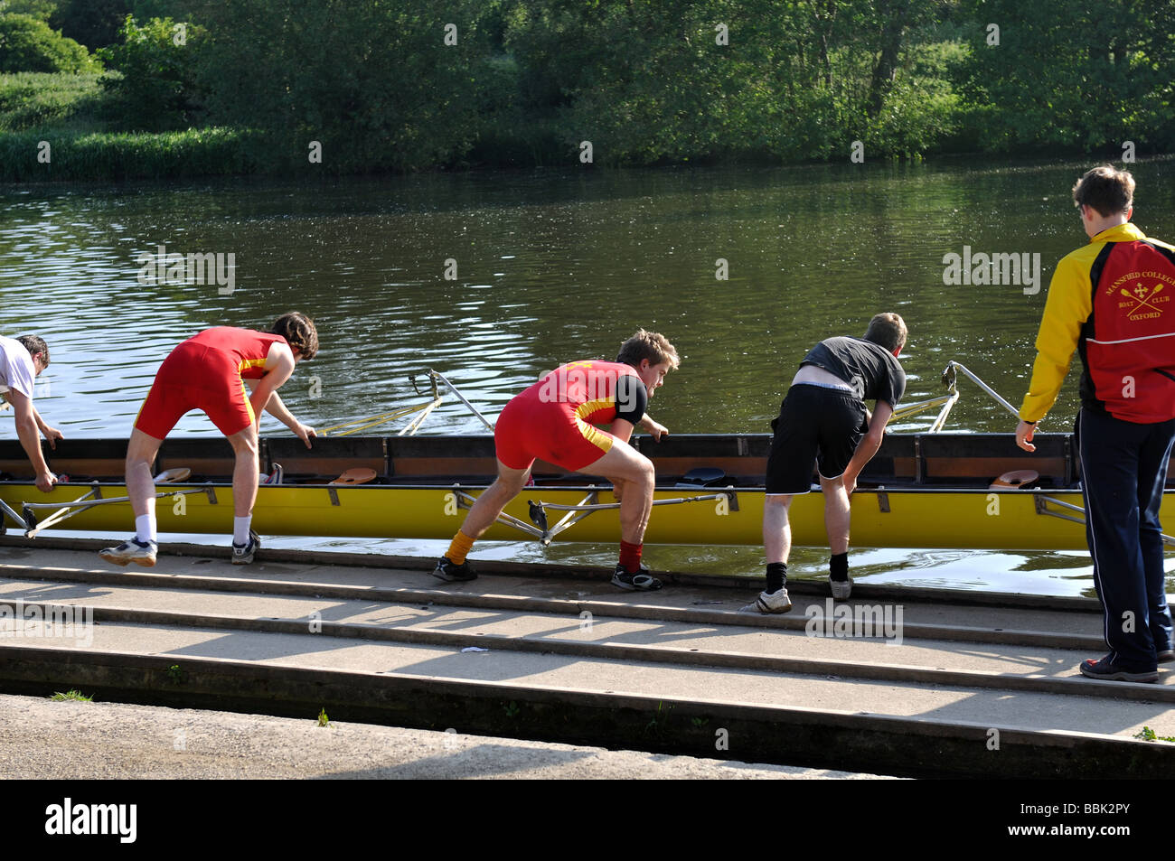 Students putting boat into River Thames, Oxford, Oxfordshire, England, UK Stock Photo