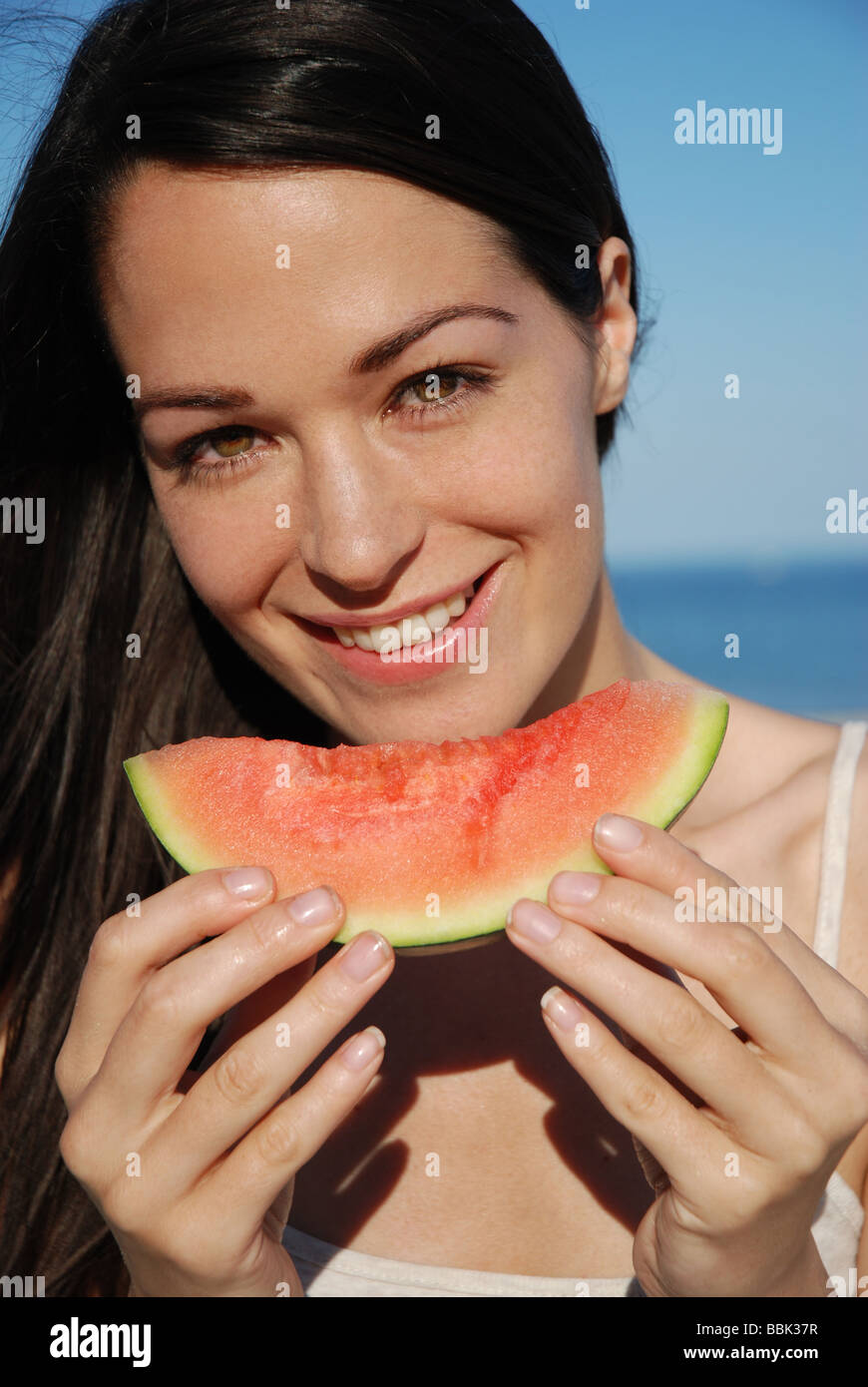 Young lady eating a piece of watermelon Stock Photo