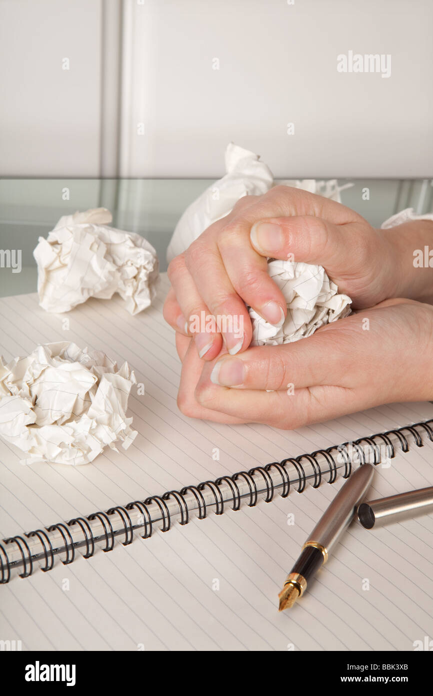 Frustrated hands squeezing a crumpled ball of paper Stock Photo Alamy