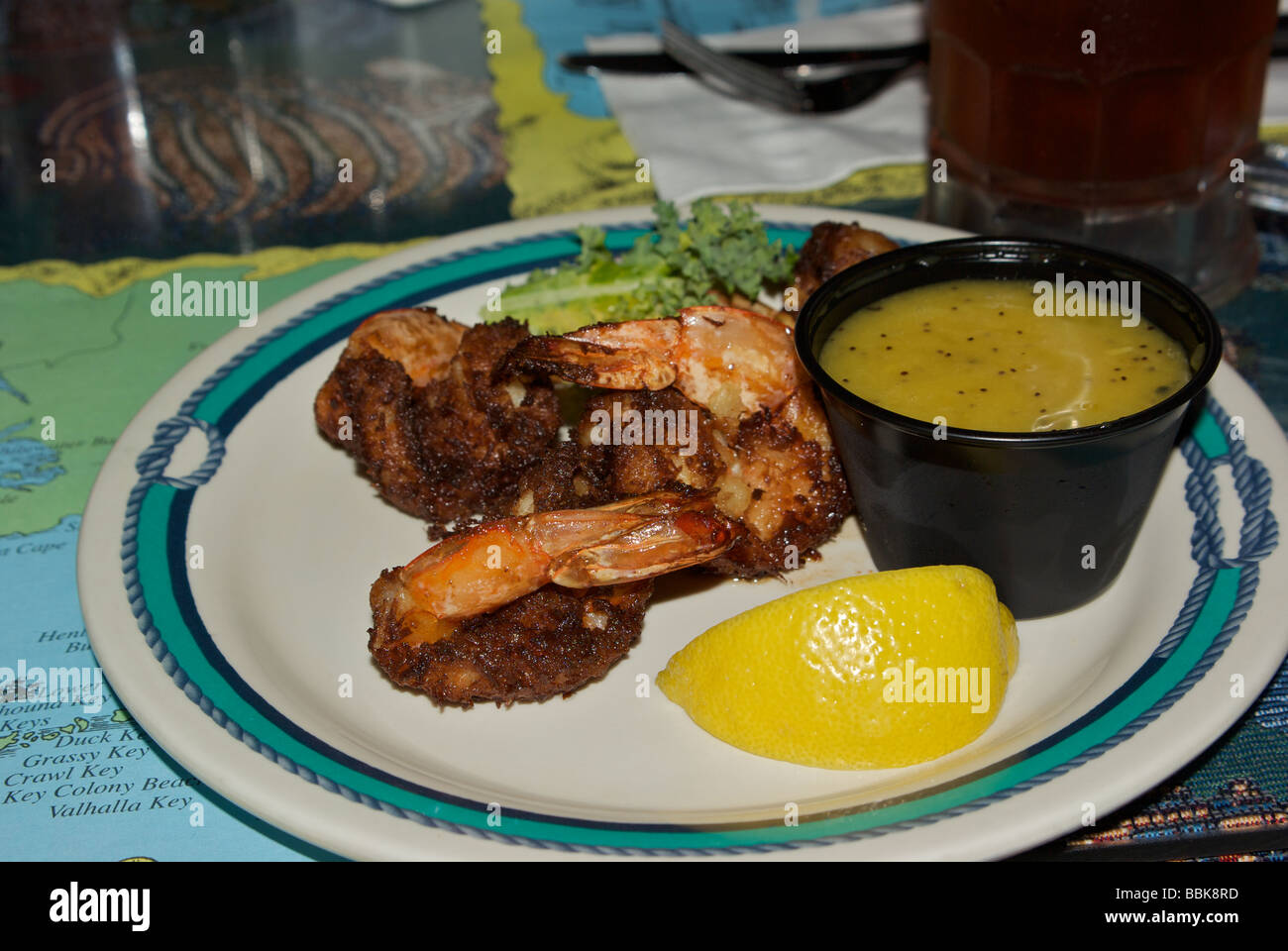 Deep fried breaded Gulf shrimp appetizer with lemon wedge and melted