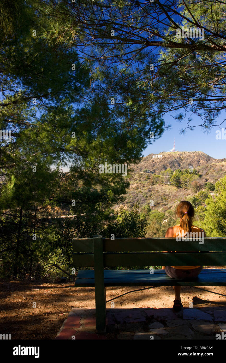 A hiker stops to look at the Hollywood sign from the Mt Hollywood Trail in Griffith Park Los Angeles California Stock Photo