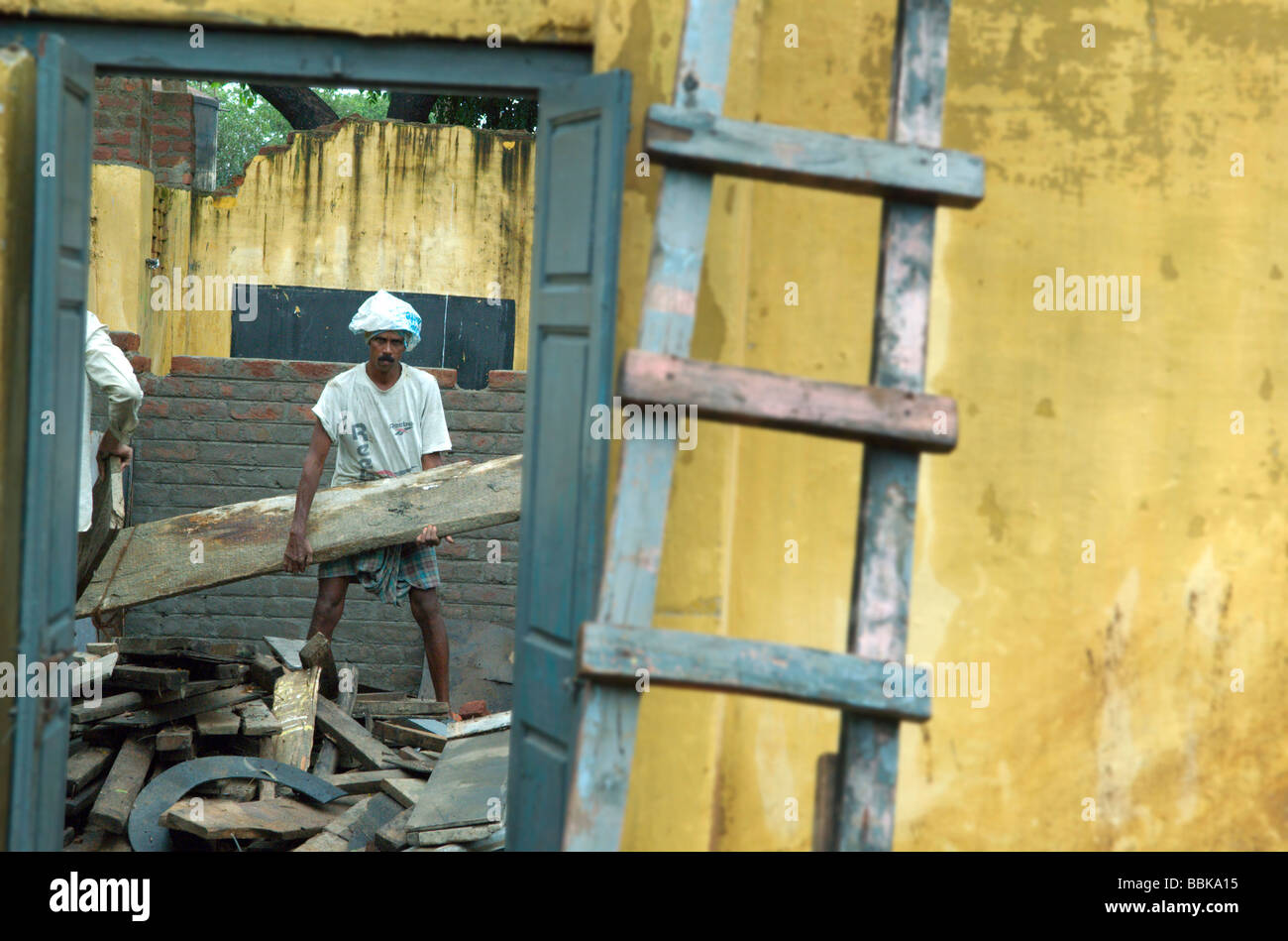 Indian builder doing construction work in one of Chennai's suburban slum playschools; India, Tamil Nadu, Chennai (Madras) ... Stock Photo
