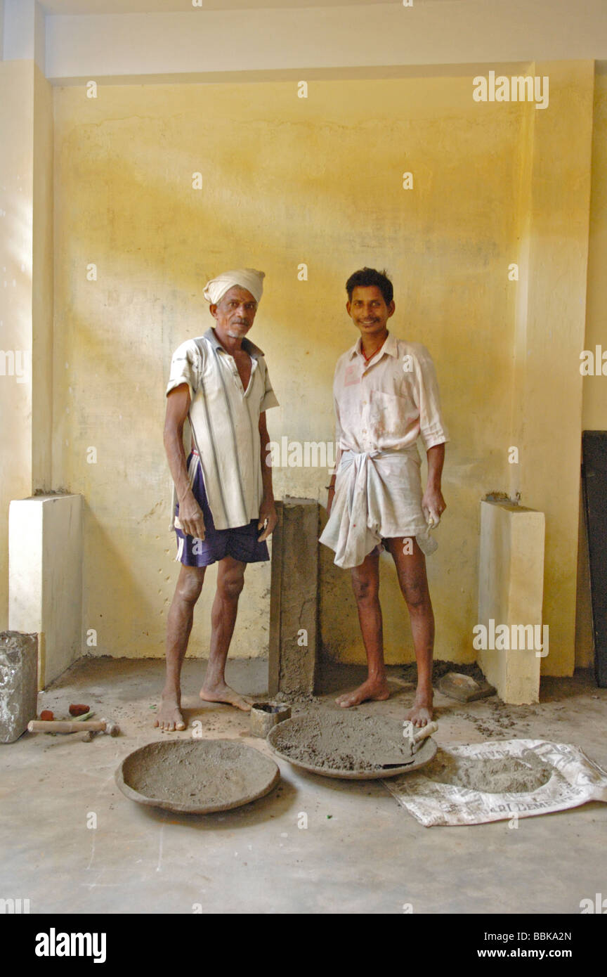 Two indian builders doing construction work in one of Chennai's suburban slum playschools; India, Tamil Nadu, Chennai (Madras).. Stock Photo