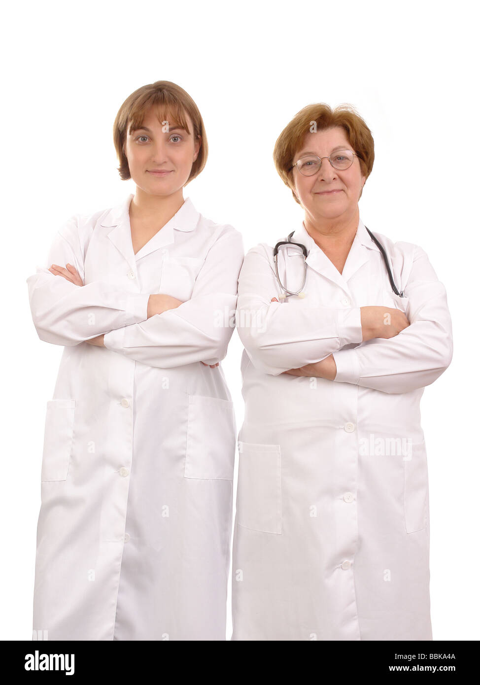 Young female medical apprentice and senior doctor posing over white background Stock Photo