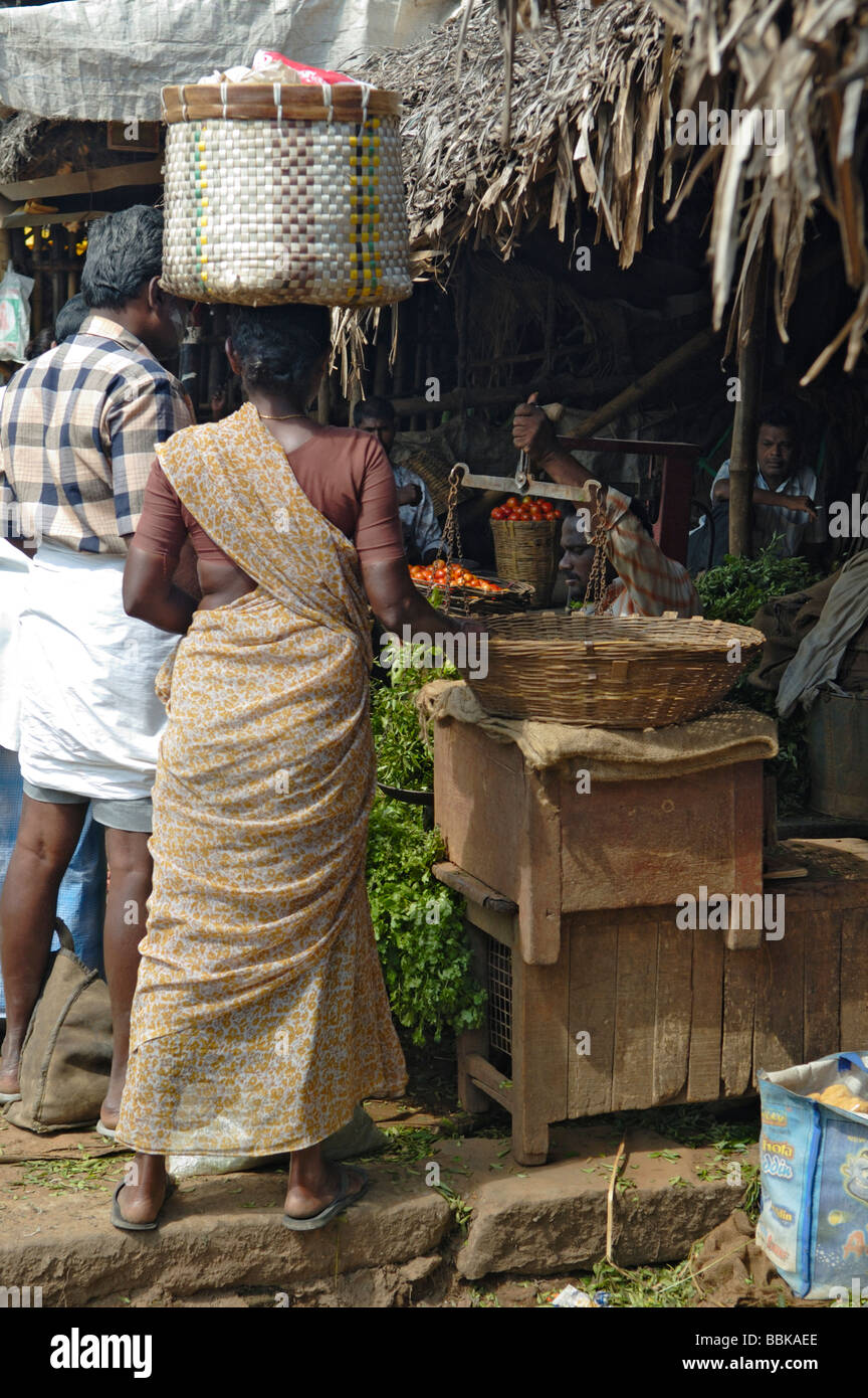 Woman carrying a large basket on her head on a market in Madurai. India, Tamil Nadu, Madurai.  No releases available. Stock Photo