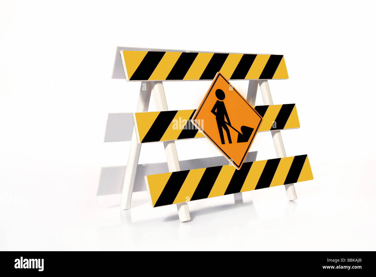 Yellow and black striped road construction barrier with Worker roadsign over white background Stock Photo