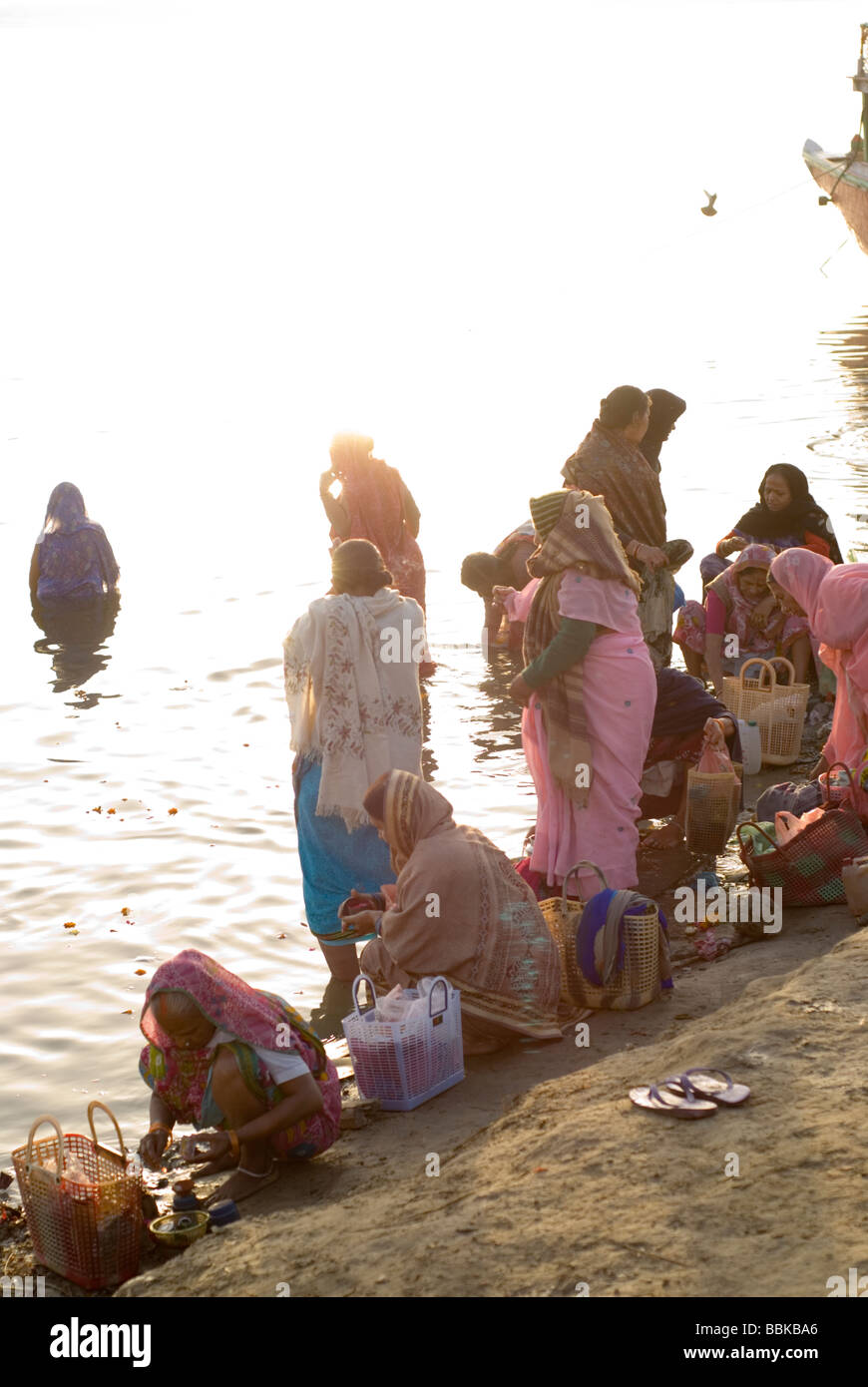 Indian women praying and making offering for river Ganges, holy for the Hindu. Assi bathing ghat, Varanasi, India. Stock Photo