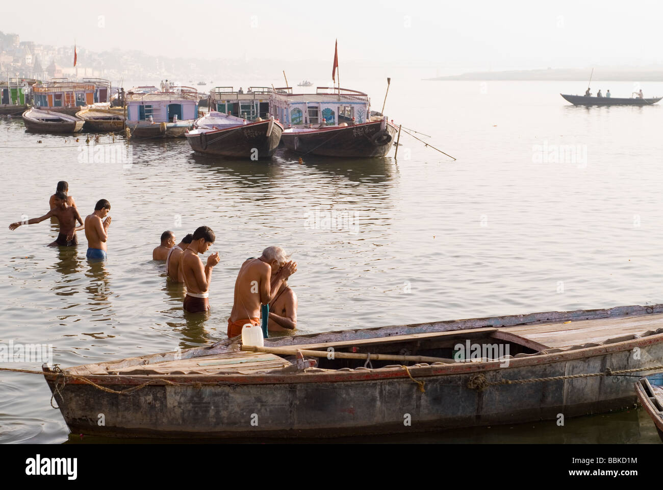 Holy men (brahmins) praying and making offering for river Ganges, holy for the Hindu. Bathing ghats, Varanasi, India. Stock Photo