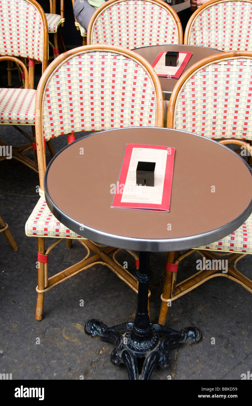 typical generic outdoor cafe setting paris france with tables and chairs on the sidewalk Stock Photo